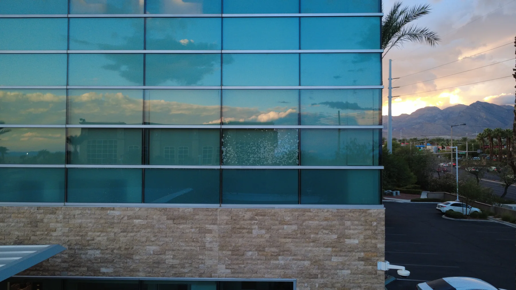 Close aerial view of a glass curtain wall and stone base