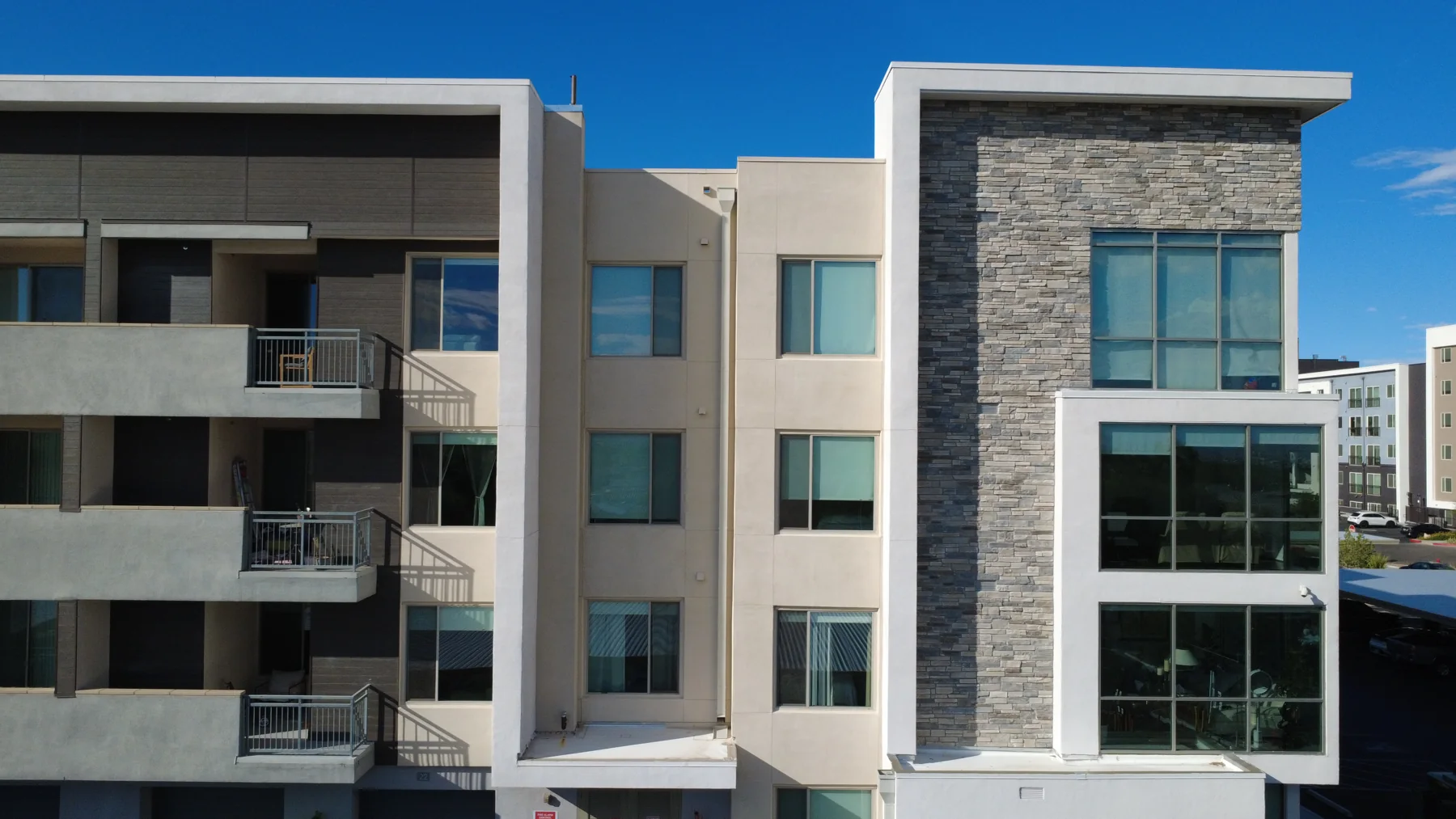 Multifamily building exterior with balconies and stacked stone